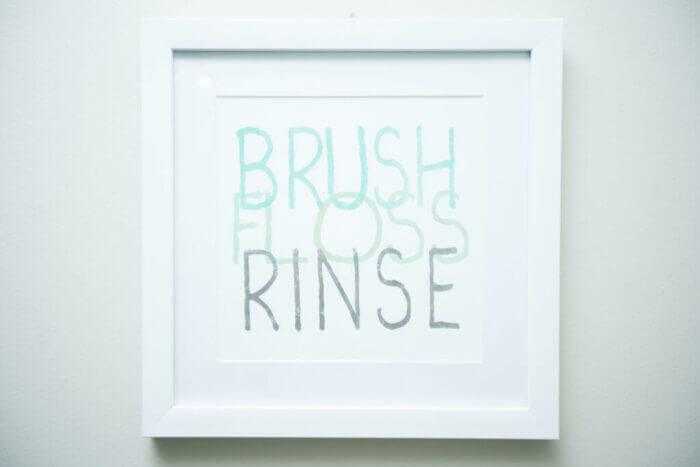 Sign on wall saying brush, rinse, floss