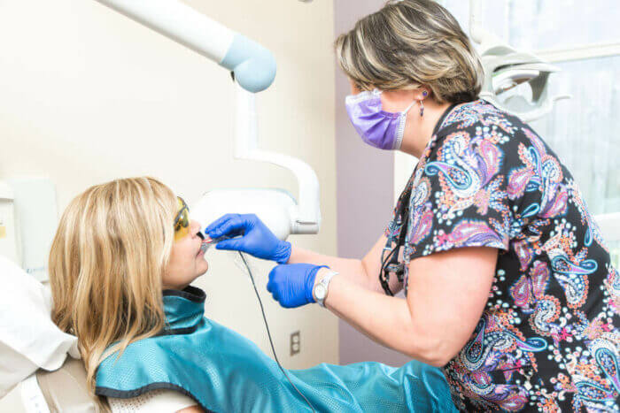 Dental technician and patient in exam room